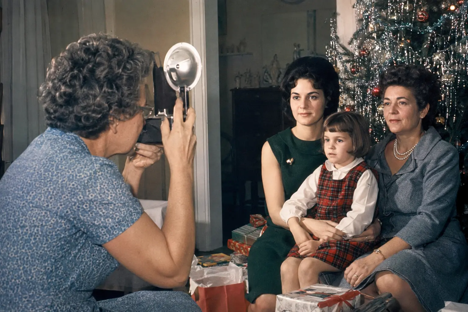 Close view of an adult loading film into a camera near a Christmas tree