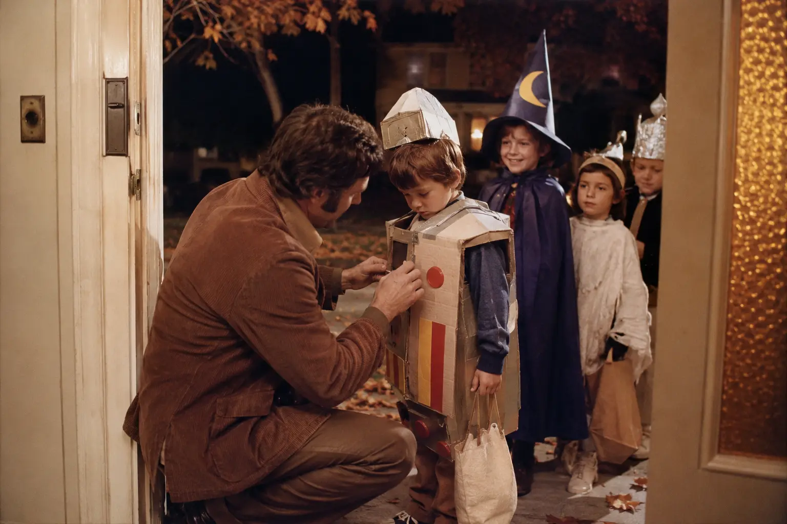 A parent repairing a child’s homemade Halloween costume in a 1970s entryway