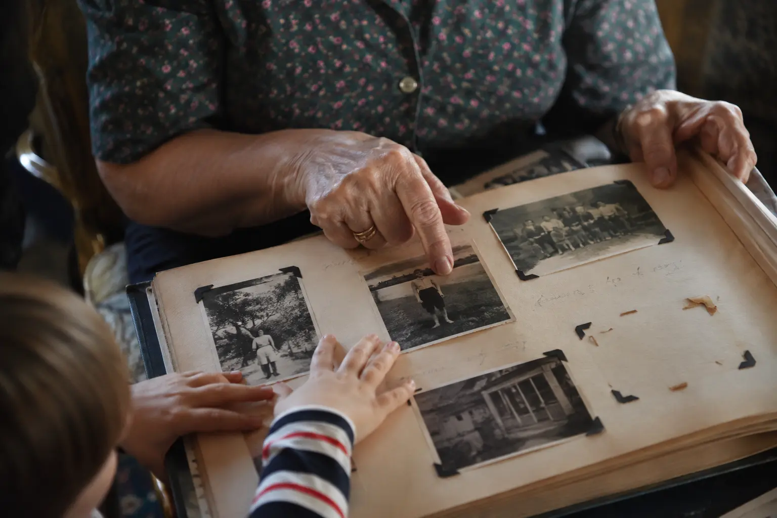 Close view of an old photo album with corner mounts and several empty spaces