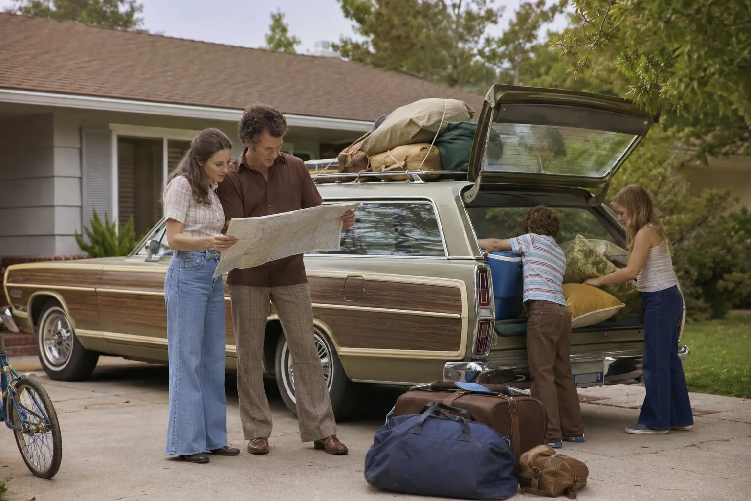 An American family beginning a road trip in a 1970s station wagon