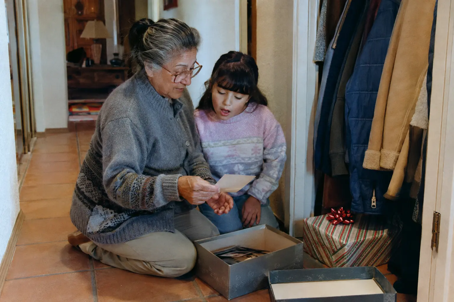 An older adult holding a child-sized coat found in a family closet