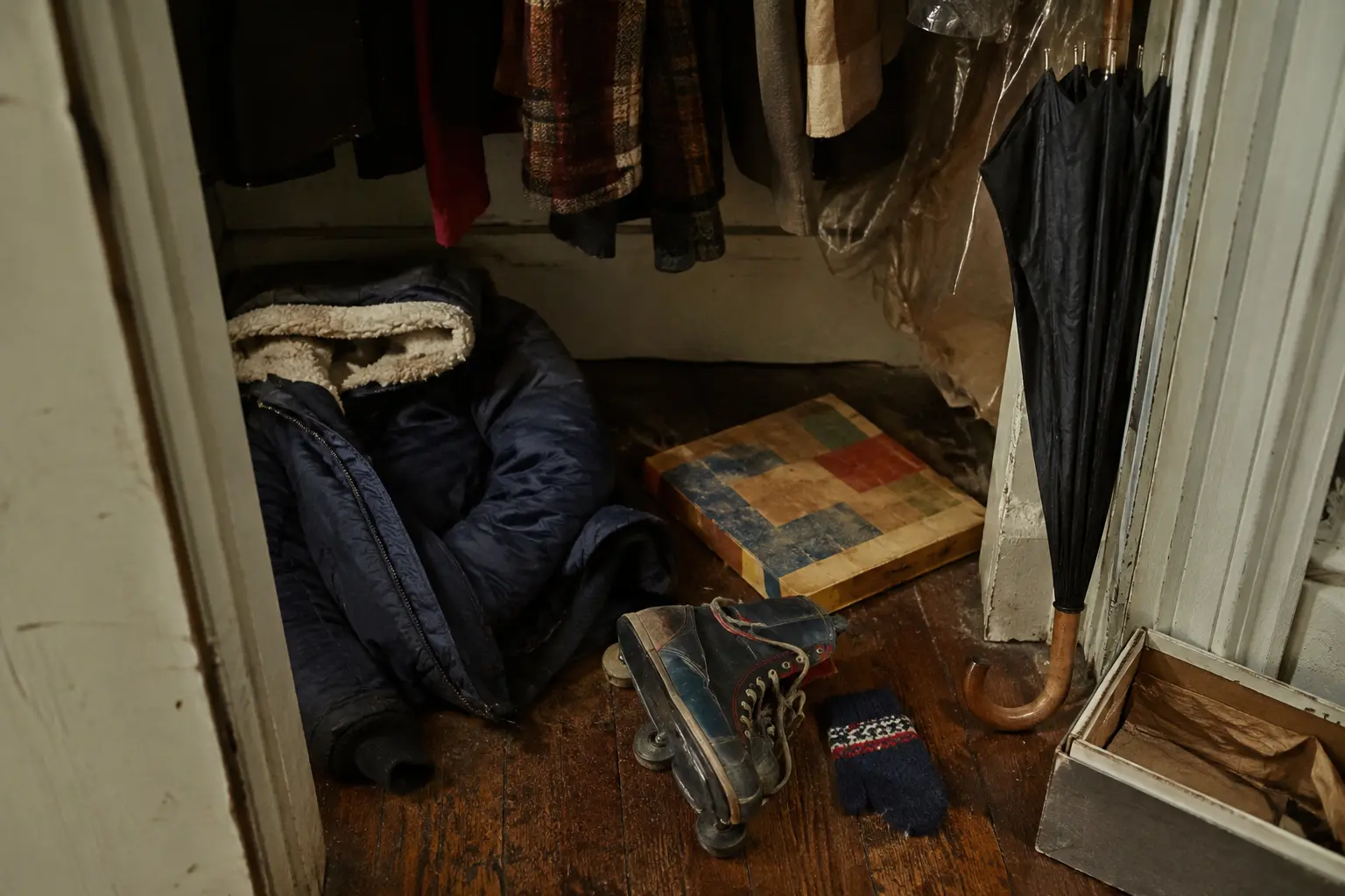 Worn family objects resting at the bottom of a crowded 1970s hallway closet